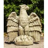 A CAST RECONSTITUTED STONE SCULPTURE of an eagle with wings spread and perched on a domed base, 76cm