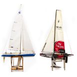 A MODEL RACING YACHT with remote control workings within, 98cm long together with a further remote