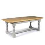 AN OAK KITCHEN TABLE the top with cleated ends, painted base with turned wooden legs united by an
