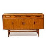 A MID TO LATE 20TH CENTURY G-PLAN TYPE TEAK SIDE CABINET with three drawers over four cupboard doors