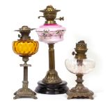 A VICTORIAN OIL LAMP with pink glass reservoir and reeded brass column support, 45cm high together