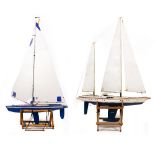 A PAINTED WOODEN TWO MASTED REMOTE CONTROL SAILING YACHT 105cm long overall with remote control