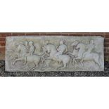 A CAST RECONSTITUTED STONE PLAQUE depicting classical cavalier figures, the plaque 150cm wide x 52cm