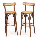 A PAIR OF STAINED BENTWOOD BAR STOOLS with caned back and seat, 36cm wide x 95cm high Condition: