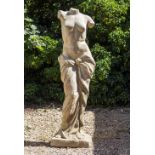 A CAST RECONSTITUTED STONE SCULPTURE depicting the legs and torso of Venus, partially draped, and on