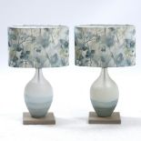 A PAIR OF VOYAGE CLEAR AND BLUE GLASS TABLE LAMPS each 40cm in height At present, there is no