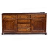 A GEORGE III OAK DRESSER BASE with crossbanded decoration to the drawers and panel cupboard doors,