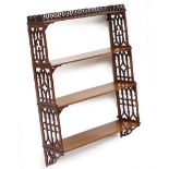 A MAHOGANY FRET CARVED FOUR TIER WALL SHELF 61cm wide x 19cm deep x 85.5cm high At present, there is