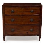 A 19TH CENTURY MAHOGANY BOW FRONTED CHEST OF THREE DRAWERS with brass handles and turned tapering