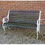 A GARDEN SEAT with white painted cast aluminium ends decorated with masks and with teak slats, 126cm