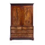 A GEORGE III MAHOGANY LINEN PRESS with twin panelled doors above two short and two long drawers with