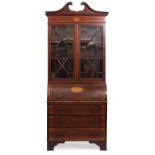 AN EDWARDIAN CYLINDER BUREAU BOOKCASE in the Georgian manner, with swan neck crest over glazed doors