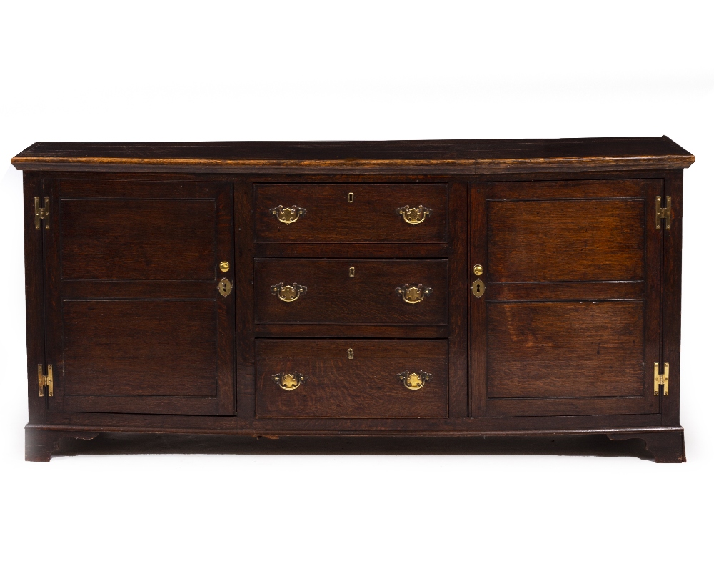 A 19TH CENTURY OAK DRESSER BASE with two panelled doors and three central drawers, on bracket