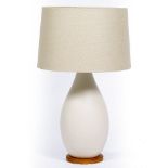 AN EGGSHELL GLAZED OVOID TABLE LAMP on a circular pine base, 27cm wide x 76cm high At present, there