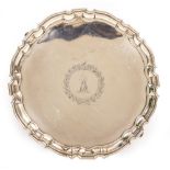 A GEORGE II SILVER SALVER with piecrust edge and central crest within a circular wreath, all