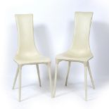 A PAIR OF CREAM LEATHERETTE UPHOLSTERED HIGH BACKED SIDE CHAIRS with turned tapering composite