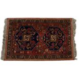 A MIDDLE EASTERN ORANGE AND BLUE GROUND RUG with geometric decoration, 100cm x 153cm together with