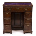 A 19TH CENTURY OAK KNEEHOLE DESK with a later baize inlaid lifting top, seven drawers, 80cm wide x