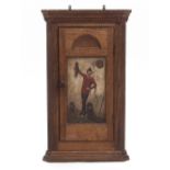 A SMALL OAK HANGING CORNER CUPBOARD the panel door inset with a decorative oil painting of an