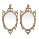 A PAIR OF GEORGIAN STYLE GILT CARVED WOOD PIER GLASSES OR MIRRORS with oval mirror plates and