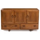 AN ERCOL LIGHT ELM SIDEBOARD CABINET with three doors above two drawers, 129cm wide x 44cm deep x