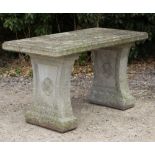 A RECTANGULAR CAST RECONSTITUTED STONE GARDEN TABLE on waisted end supports with flowerhead
