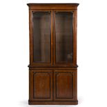 A 19TH CENTURY OAK LIBRARY CABINET with ebonised mouldings, the upper glazed section enclosing