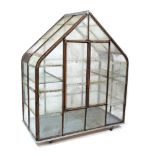 A WROUGHT IRON GLAZED MINIATURE GREENHOUSE OR FERN HOUSE with pitched roof and shelves within, the