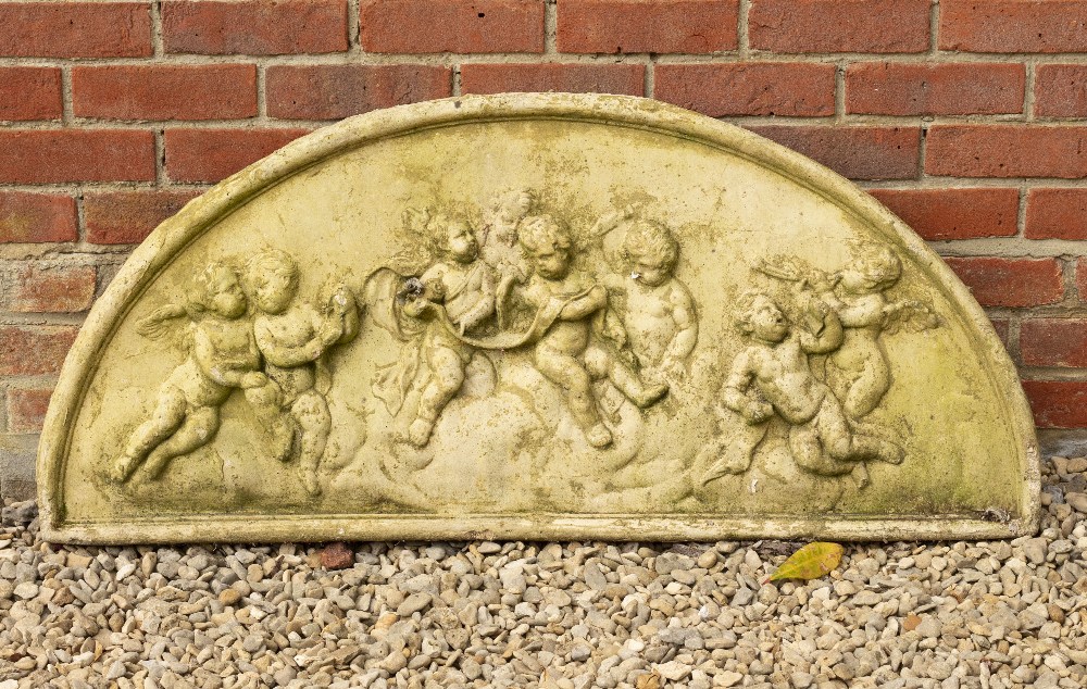 A D SHAPED CAST RECONSTITUTED STONE PLAQUE depicting cavorting putti, 116cm wide x 52cm high