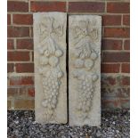 A PAIR OF SMALL RECONSTITUTED STONE PLAQUES cast with ribbon tied fruit swags, each plaque 20cm wide