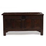 AN 18TH CENTURY OAK CHEST OR COFFER with panelled top, front and sides, the lifting lid with old