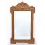 A PINE FRAMED WALL MIRROR with a carved acanthus leaf and scallop shell mount, 48.5cm wide x 87.