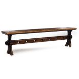 A VICTORIAN OAK BENCH with shaped end supports and trefoil decoration to the pierced stretcher,