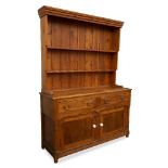 A PINE DRESSER with plate rack above, the base with two drawers over two cupboard doors, all
