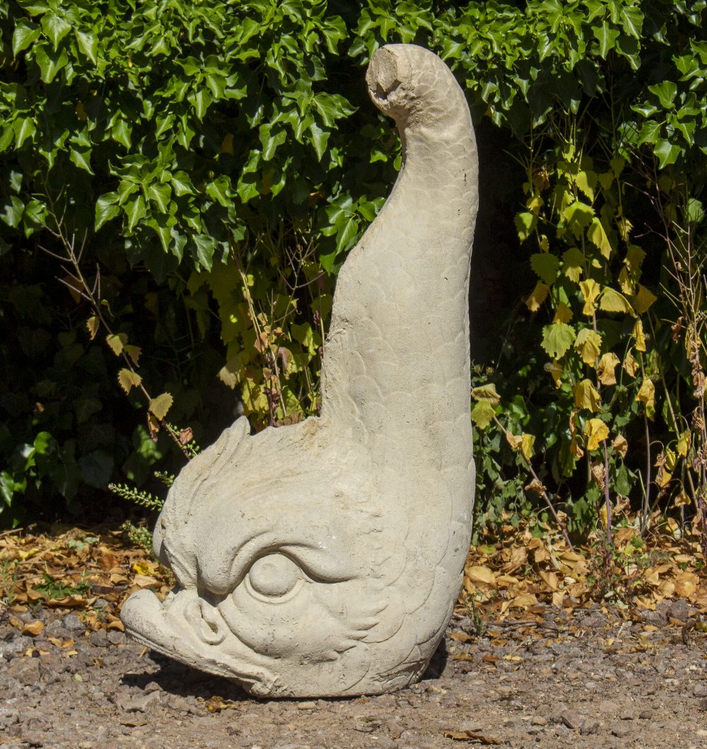 A CAST RECONSTITUTED STONE SCULPTURE of a classical dolphin, 31cm wide x 48cm deep x 88cm high