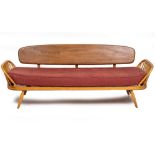 AN ERCOL LIGHT ELM THREE SEATER SETTEE OR DAY BED with a single plank back and spindle supports,
