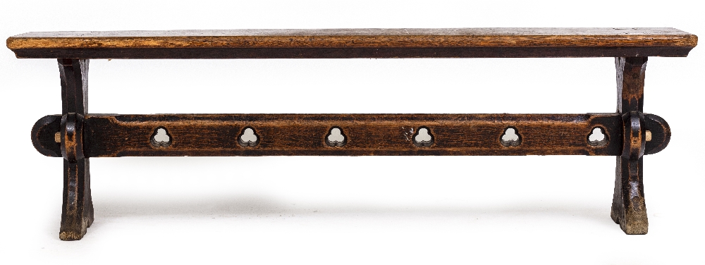 A VICTORIAN OAK BENCH with shaped end supports and pierced trefoil decoration to the stretcher,