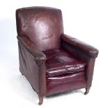 AN EARLY 20TH CENTURY RED LEATHER UPHOLSTERED ARMCHAIR with square tapering feet and brass