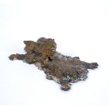 A COLD PAINTED LEAD FIGURE of a lion standing on a tiger rug, 12cm x 8cm Condition: wear and