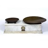 A MID 20TH CENTURY SPANISH SHOP WEIGHING SCALES the greyed marble body beneath two brass pans,