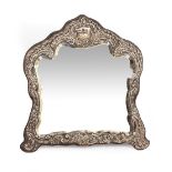 A VICTORIAN EMBOSSED SILVER MOUNTED DRESSING TABLE MIRROR with shaped and bevelled glass, 34cm