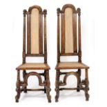 A PAIR OF CAROLEAN STYLE OAK SIDE CHAIRS with caned high backs, caned seats and scrolling front legs