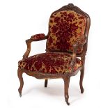 A LATE 19TH CENTURY FAUTEUIL WALNUT OPEN ARMCHAIR with floral decorated overstuffed seat and back