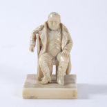 A 19TH CENTURY CARVED IVORY FIGURE OF NAPOLEON sitting in a chair, on a square base, 4.5cm wide x