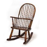 A 19TH CENTURY OAK CIRCULAR SPINDLE BACKED RECLINING CHAIR on turned legs united by a H stretcher,