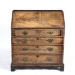 A GEORGE III MAHOGANY BUREAU the fall front opening to reveal pigeon holes and drawers above four