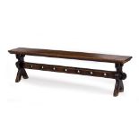 A VICTORIAN OAK BENCH with shaped end supports and trefoil decoration to the pierced stretcher,