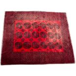 A MIDDLE EASTERN RED GROUND RUG with geometric decoration, 263cm x 326cm Condition: patches of