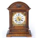 AN EDWARDIAN WALNUT CASED MANTLE CLOCK with a brass and silver dial, having roman numerals, to