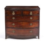 A 19TH CENTURY MAHOGANY BOW FRONTED CHEST OF TWO SHORT AND THREE LONG DRAWERS with oval brass